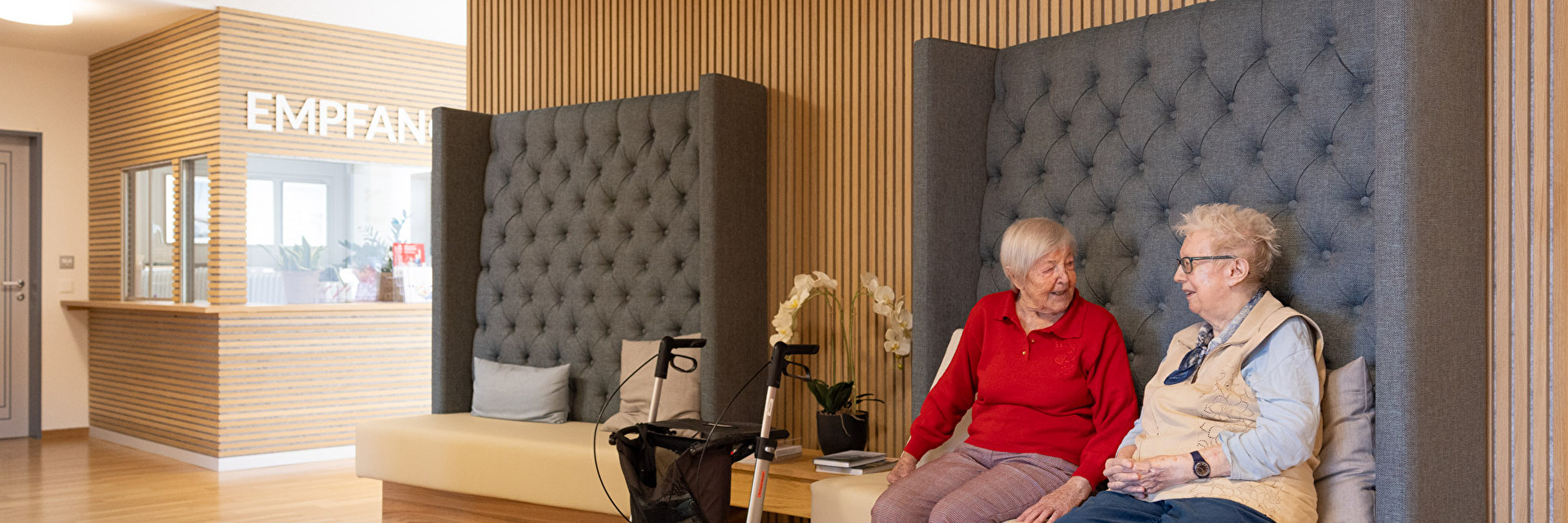 Zwei ältere Frauen unterhalten sich auf einer Bank