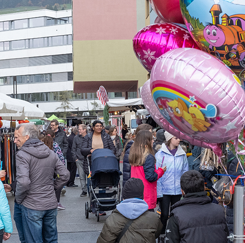 Leute spazieren Ständen entlang