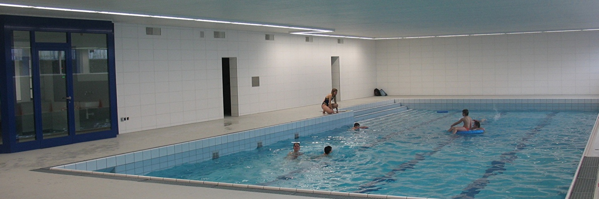 Hallenbad mit Schwimmern und Schwimmerinnen