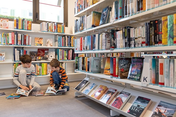 Zwei Buben schauen Bücher an