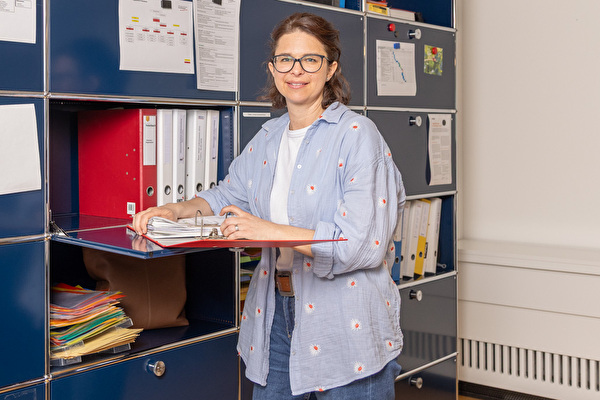 Frau mit Karten in der Hand im Gespräch mit einem Mann