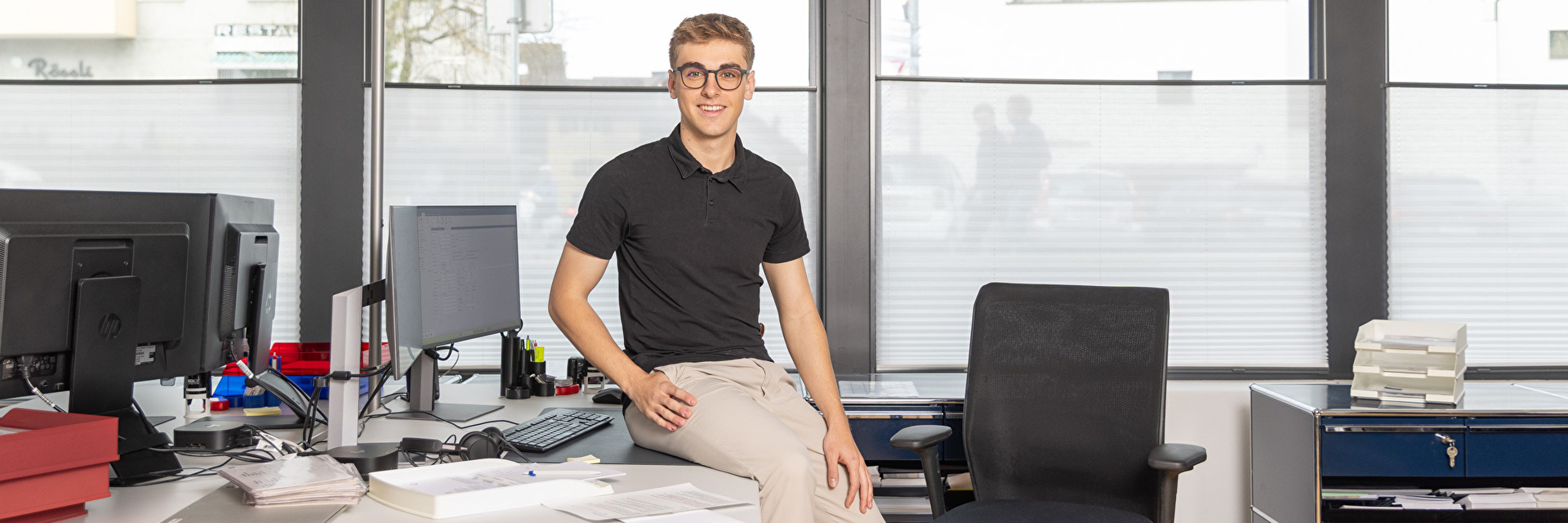 Tim Bürgi sitzt auf seinem Pult im Einwohneramt