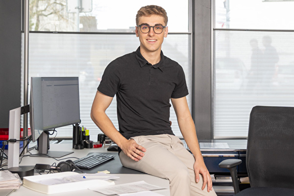 Tim Bürgi sitzt auf seinem Pult im Einwohneramt