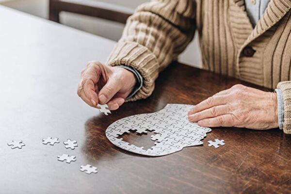 Ein Senior macht ein Puzzle