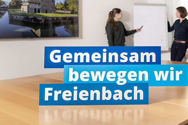 Sitzungszimmer mit Mitarbeitenden und dem Claim Gemeinsam bewegen wir Freienbach