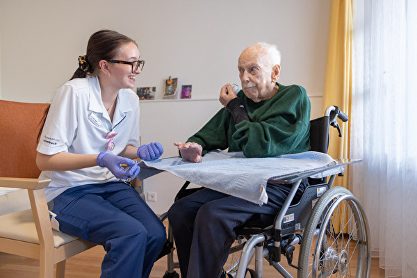 Junge Pflegerin behandelt älteren Mann