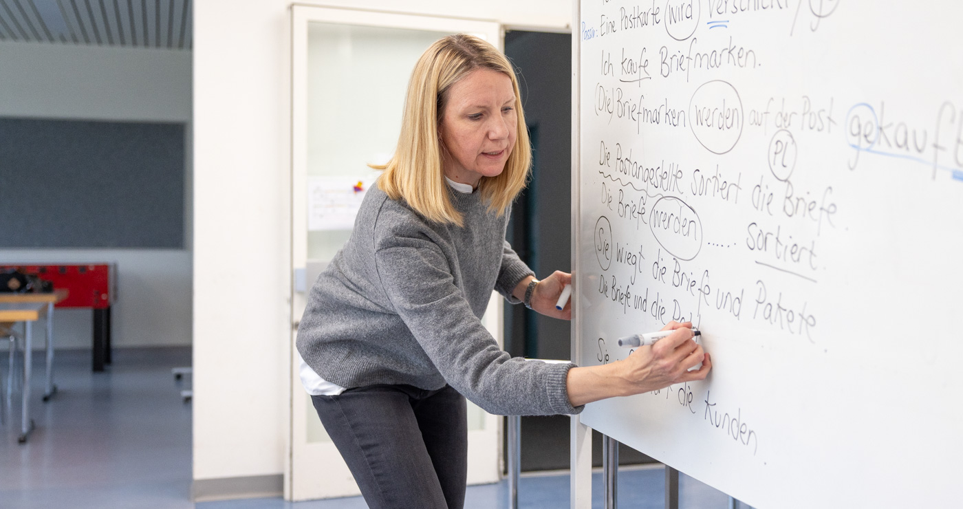 Deutschkurslehrerin am Whiteboard schreibt etwas
