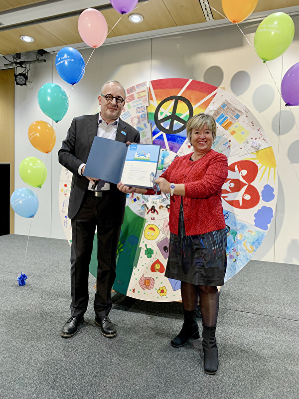 Stadträtin Vroni Straub-Müller nimmt nach der gelungenen Rezertifizierung mit Freude die UNICEF-Auszeichnung «Kinderfreundliche Gemeinde» von Cyrill Tait, stv. Geschäftsleiter UNICEF Schweiz und Liechtenstein, entgegen.
