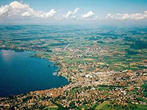 Die Stadt Zug mit Blick gegen Westen, wo sich  Steinhausen, Cham und Hünenberg – der so genannte Ennetsee – befindet. Am Horizon der Lindenberg (Kanton Aargau).