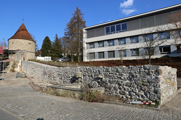 Mauerabschnitt beim Huwilerturm mit Bachdurchlass im Vordergrund und restaurierte Mauerkrone nach der Restaurierung.