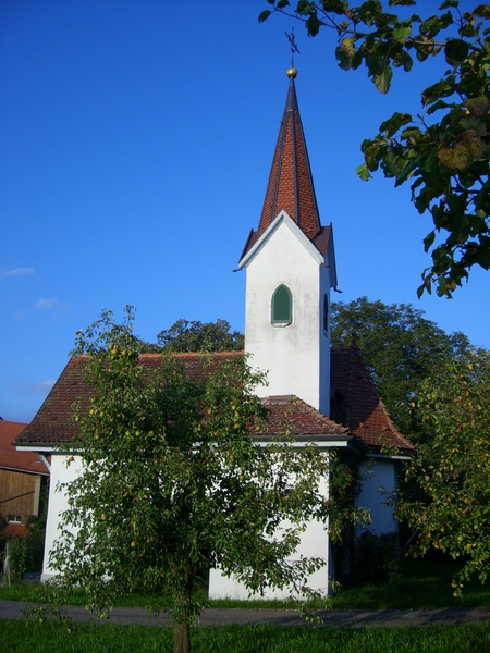 Kleine weisse Kapelle zwischen Obstbäumen