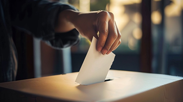 Bild Stimmzettel in Urne einlegen