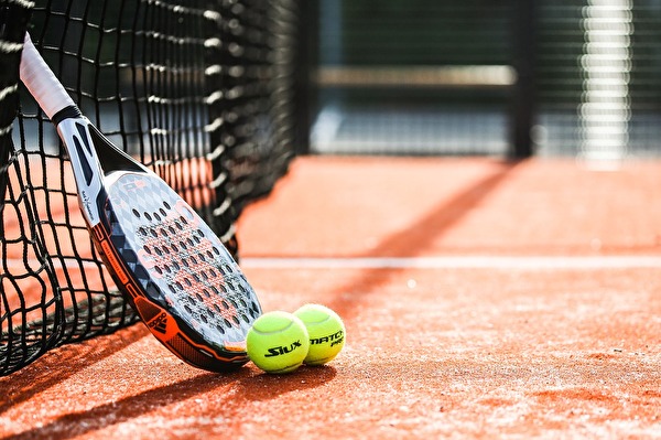 Tennisracket mit zwei Bällen am Netz