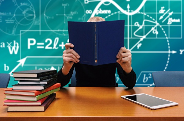 Mann mit Bücher auf Schultisch