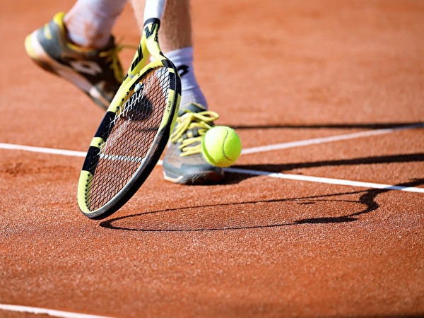 Tennisspieler mit Schläger und Ball