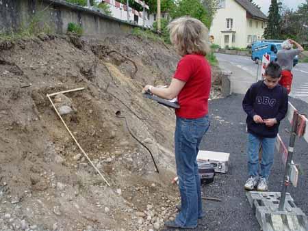 Frau Backman erfasst sowohl fotografisch als auch zeichnerisch den Fundort des Teilschädels.
