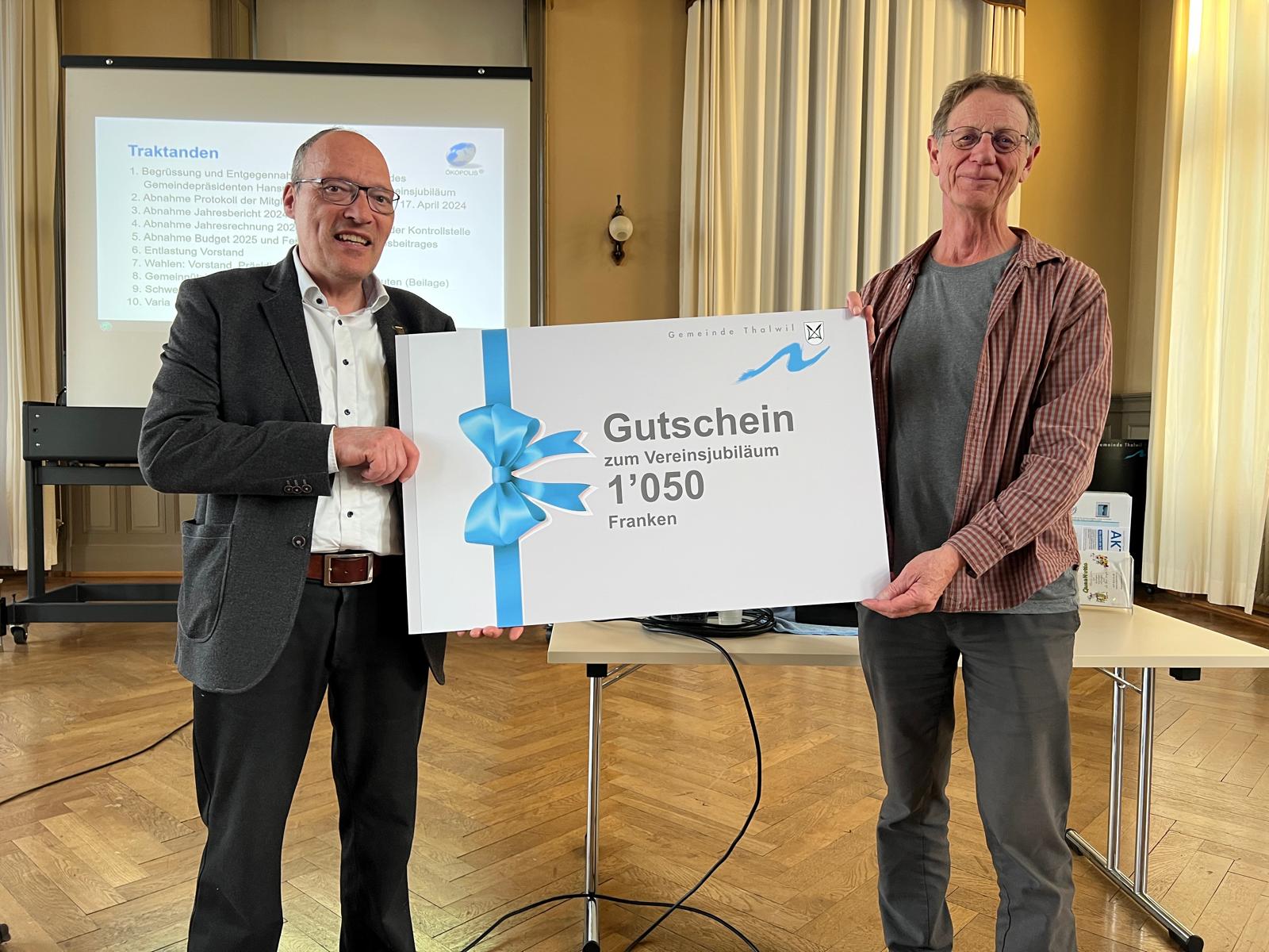 Zwei Männer halten einen symbolischen Gutschein
