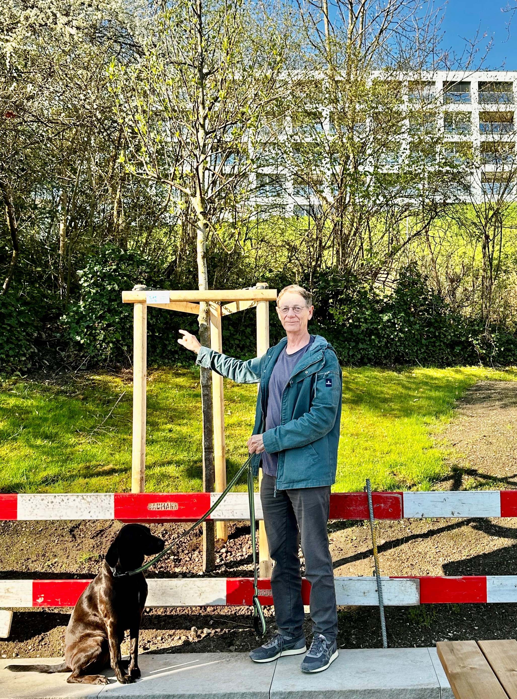 Ein Mann mit Hund vor einem Baum