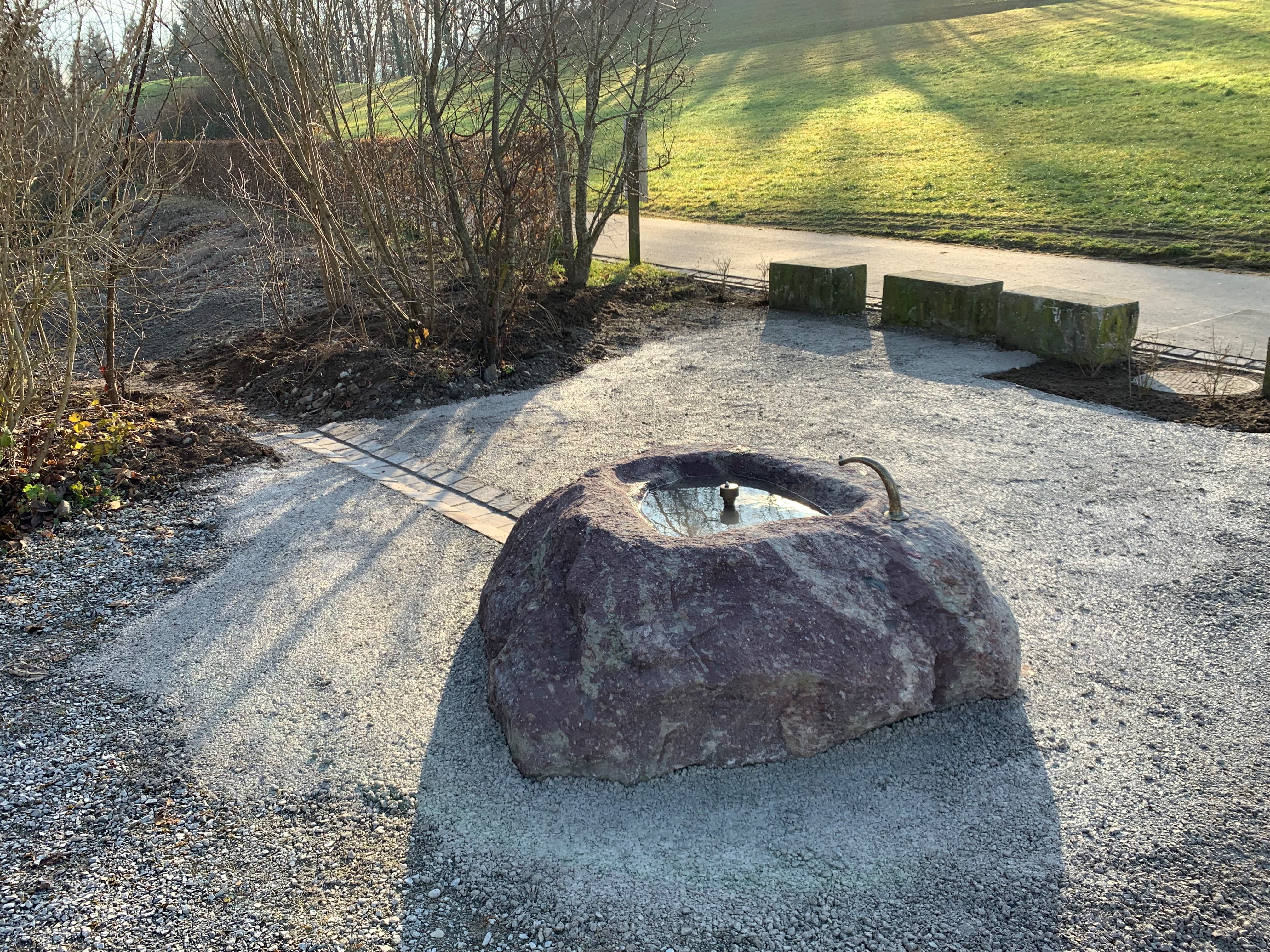 Findlingsbrunnen aus Glarner Sernifit beim Schulhaus Schweikrüti in Gattikon.