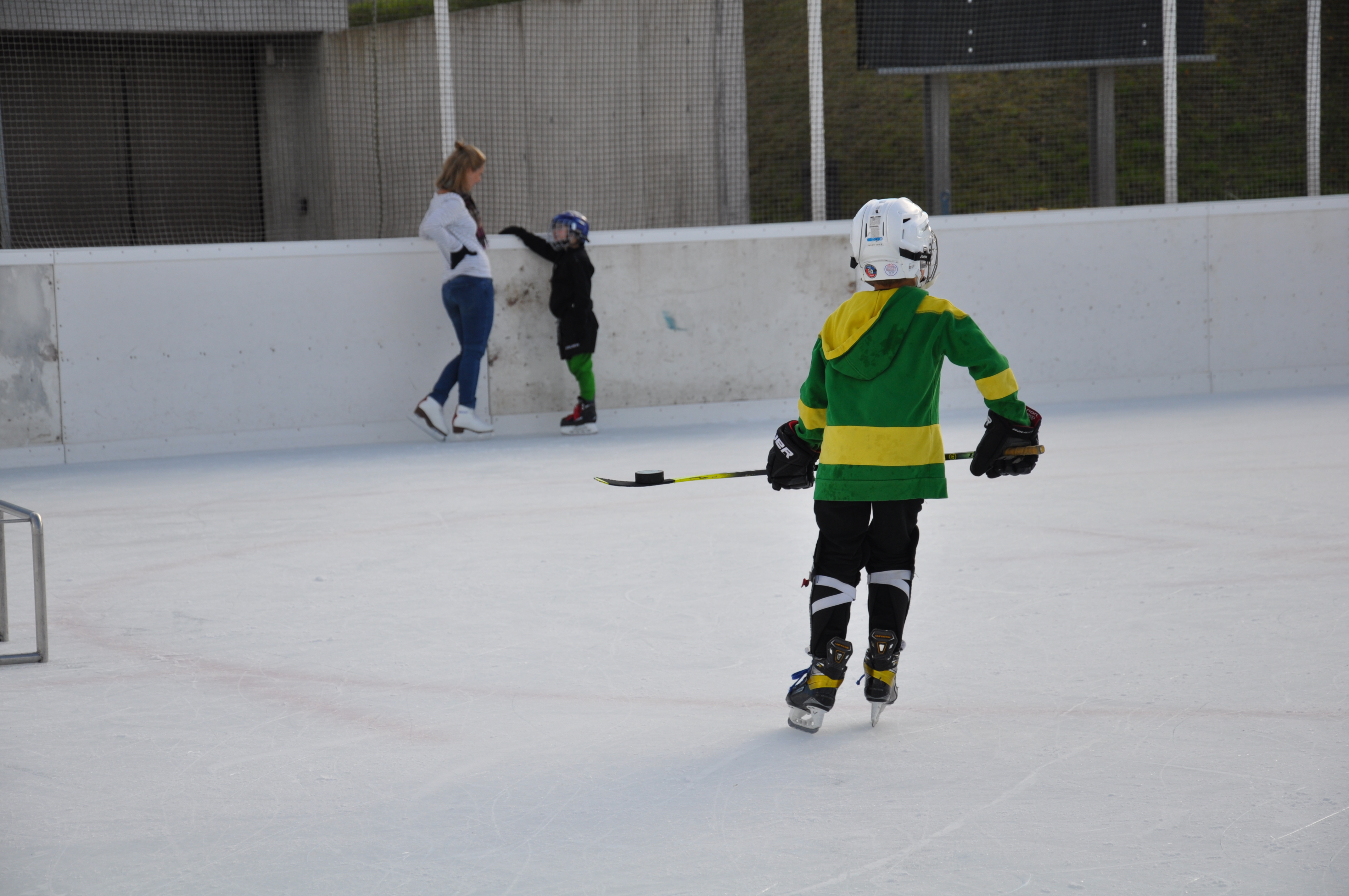 Junge mit Einhockeyschläger auf der Eisbahn Brand im November 2021