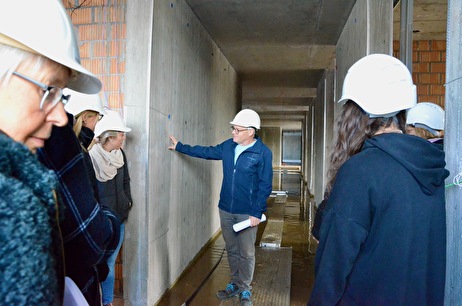 In den Fluren belebt eine Brettstruktur die Betonwände – Bauleiter Ivo Gächter führt die Mitarbeitenden durchs neue Alterszentrum Zehntfeld 