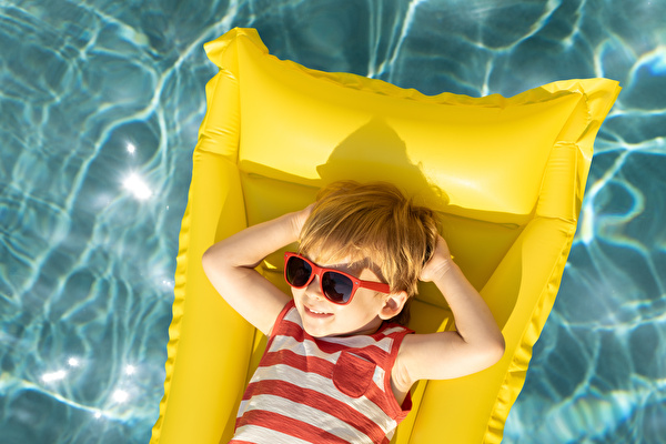 Junge mit Sonnenbrille auf Luftmatraze