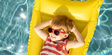 Junge mit Sonnenbrille auf Luftmatraze