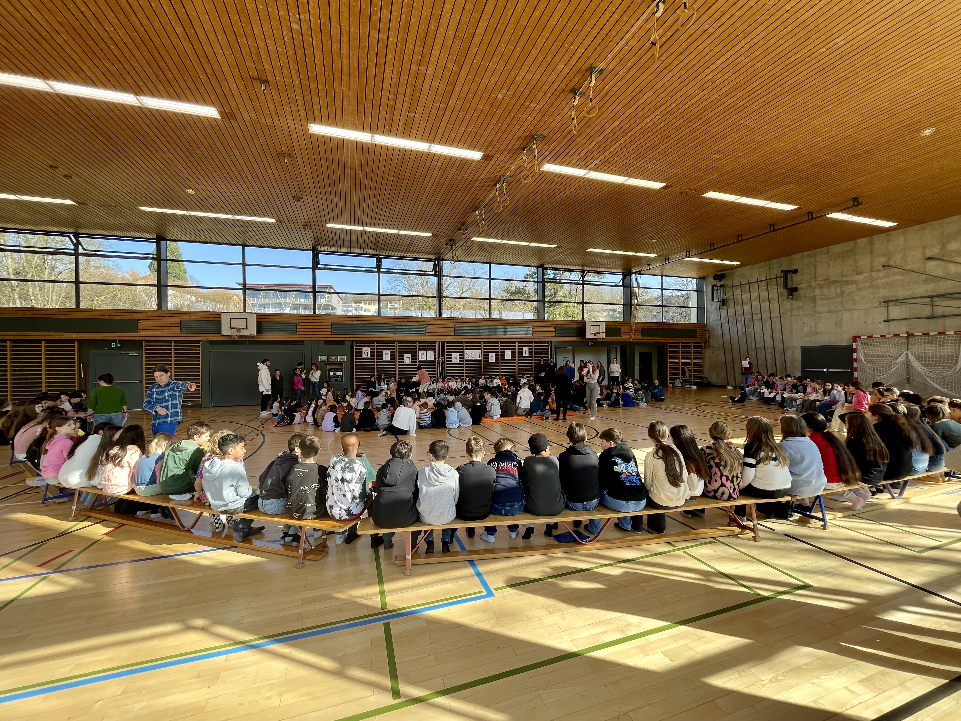 Vom Kindergarten bis zur 6. Klasse versammeln sich einmal jährlich alle Schüler*innen in der Turnhalle