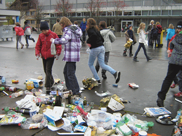 Kinder sammeln Abfall auf dem Pausenplatz