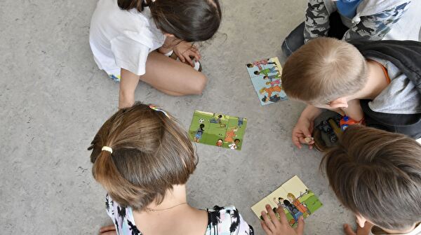 Welches Kinderrecht ist dargestellt? Eine 2.-Klass-Gruppe im Schulhaus Langelen vertieft sich in Bilder und Gesprächen.