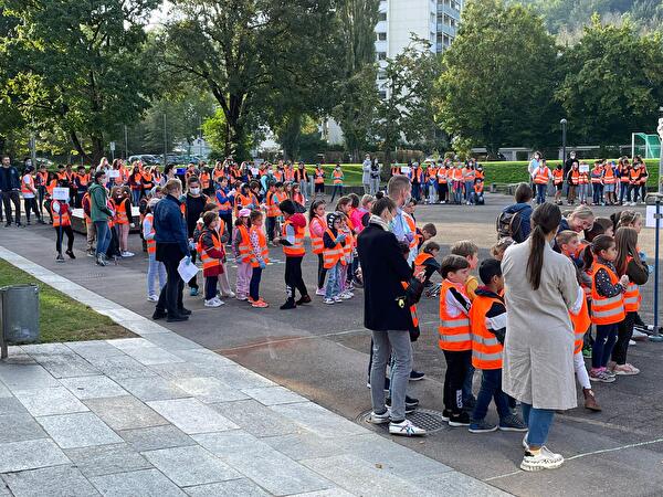 Schülerinnen und Schüler stehen in Leuchtwesten bereit.