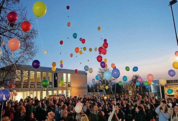 Bunte Ballone steigen vor dem Neubau in den Himmel