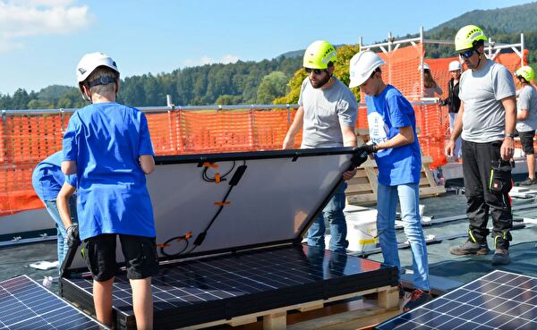 Schüler montieren Solarpanel auf Dach