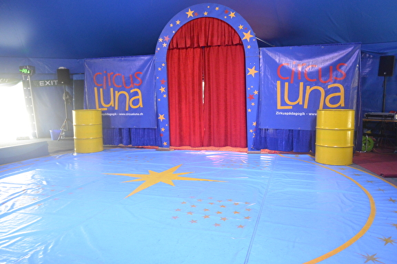 Blaue Manege mit gelben Sternen und einem roten Vorhang
