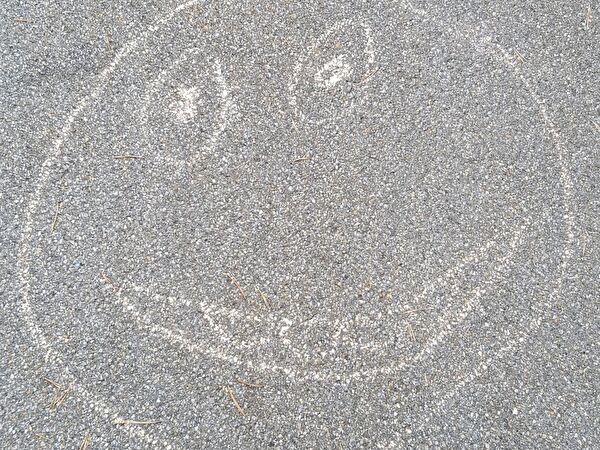Smiley mit Kreide auf Asphalt
