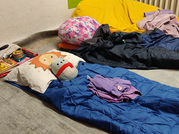 Schlafsack mit Kuscheltier und Büchern