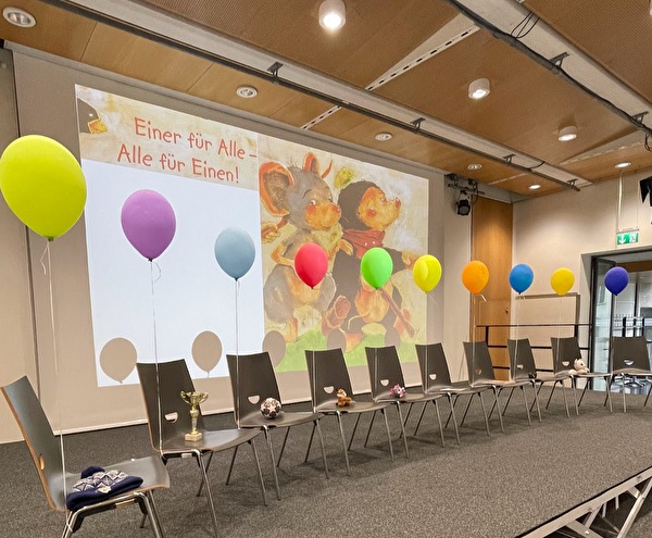 Stühle auf der Bühne, mit bunten Ballons und Gegenständen