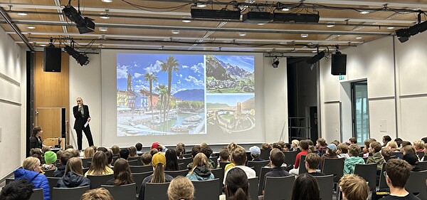 Bühne mit Schüler und Bilder auf der Leinwand