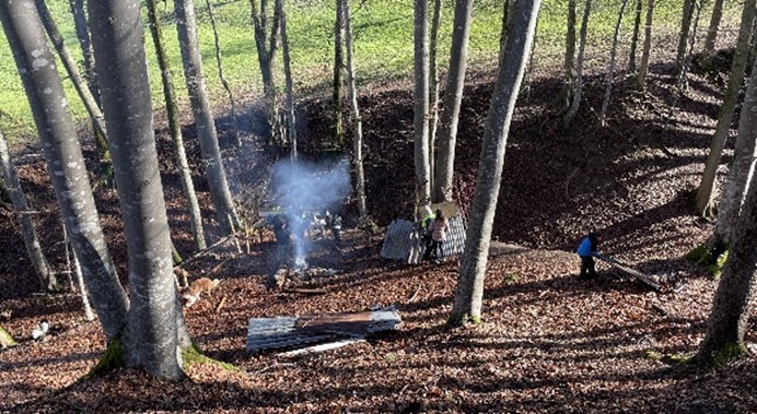 Ein Feuer an einer Feuerstelle im Wald