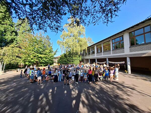 Das Schulhaus Felsberg versammelt sich auf dem Pausenplatz