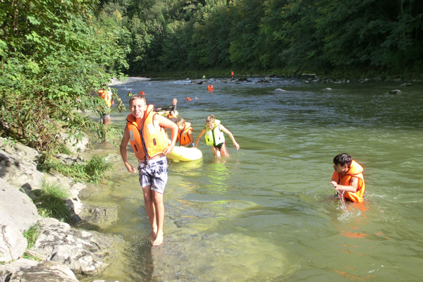 Schulklasse am Baden mit Schwimmwesten uns Schwimmring