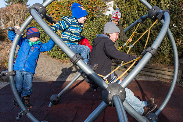 Zivildienstleistender mit Kindern auf dem Klettergerüst