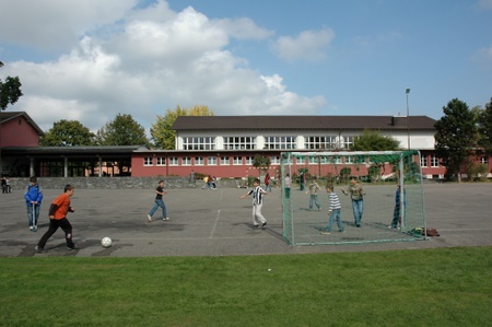 Schulhaus Pünt mit Pausenplatz, hinten die Turnhalle