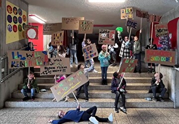 Kinder demonstrieren mit selbstgebastelten Tafeln und Sprüchen gegen Beleidigungen an der Schule