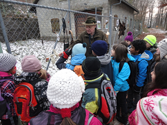 Ein Jäger erklärt den Kindern Gegenstände eines Jägers.