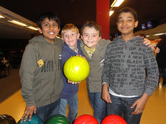 4 Jungs posieren mit Bowling-Kugel