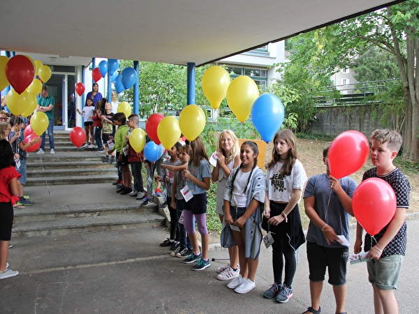 Kinder stehen mit Ballons Spalier