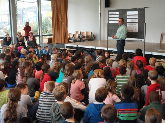 Herr Lüthi bringt den Kindern das Friedenslied bei.