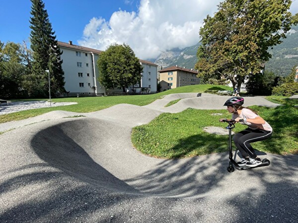 Mädchen auf Kickboard auf dem Pumtrack