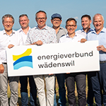 Mitbeteiligte Menschen hinter Schild mit Aufschrift energieverbund wädenswil